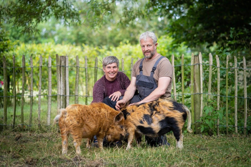 Rina en Mart met twee varkens op het erf